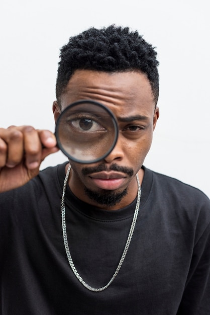 Free photo african man playing with a magnifying glass