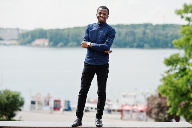 African man posed at street of city wear on blue shirt and black pants