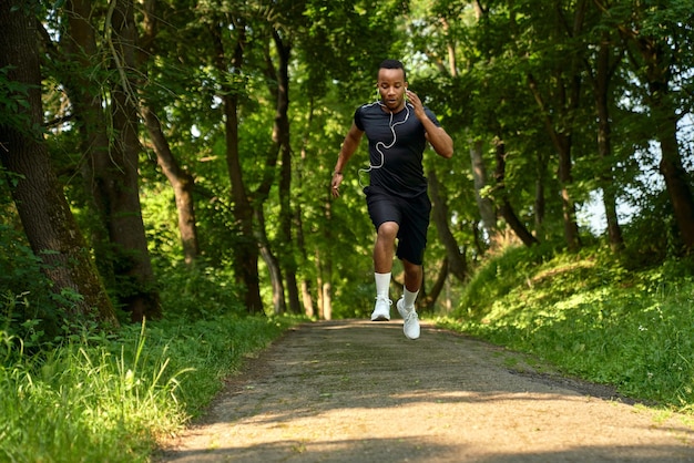 Африканский мужчина бежит по дорожке в парке