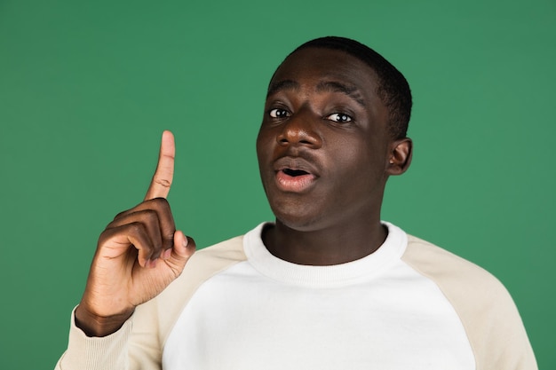 African man's portrait isolated on green studio background with copyspace