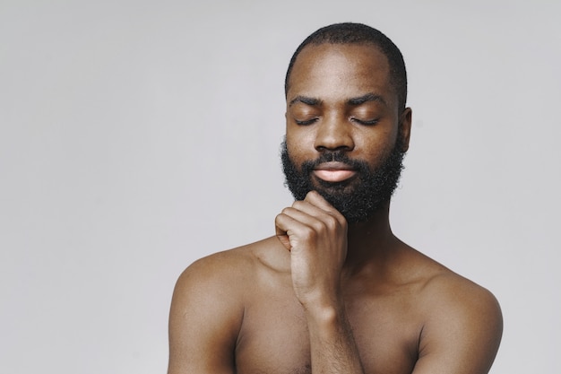 Free photo african man in a studio. white wall.  man without clothes.