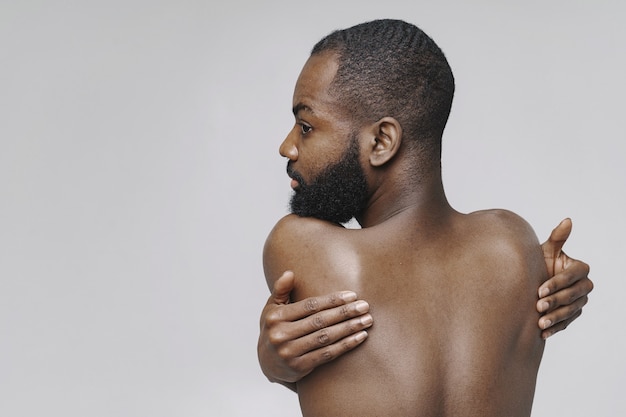 Free photo african man in a studio. white wall.  man without clothes.