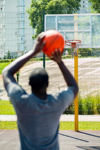 Free photo african man throwing a ball in the hoop