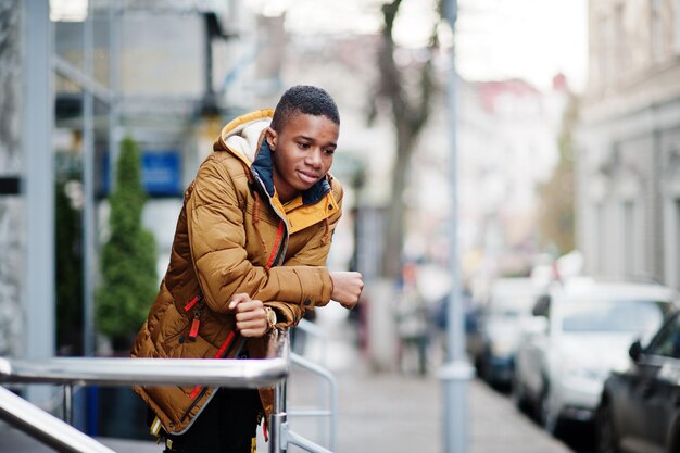 African man wear on orange jacket at cold weather posed outdoor