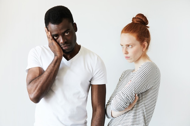 Free photo african man in white t-shirt and redhead caucasian woman in striped top