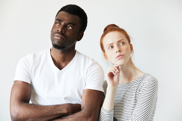 Free photo african man in white t-shirt and redhead caucasian woman in striped top