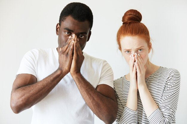 African man in white T-shirt and redhead Caucasian woman in striped top