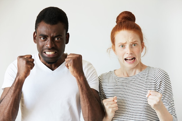 Free photo african man in white t-shirt and redhead caucasian woman in striped top