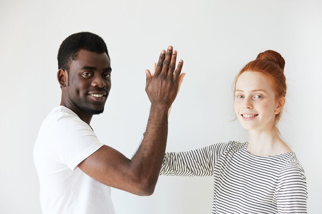 African man in white T-shirt and redhead Caucasian woman in striped top