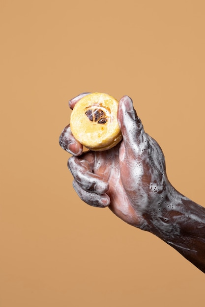 Free photo african person washing hands with soap isolated on orange