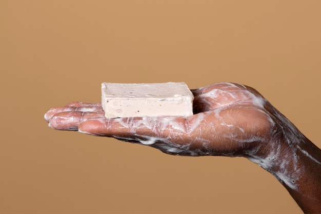 Free photo african person washing hands with soap isolated on orange