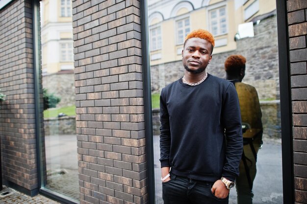 African red haired man wear black outfit posing outdoor