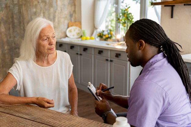 African social worker helping a senior woman