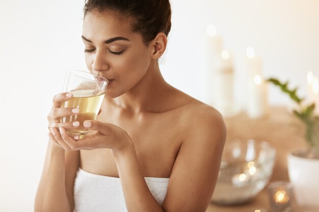 african woman drinking green tea resting in spa salon.