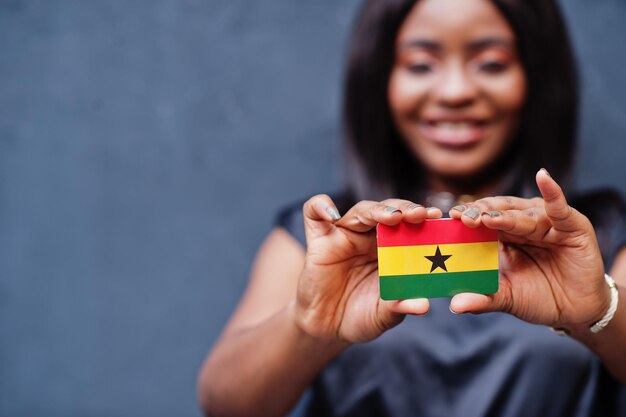 African woman hold small Ghana flag in hands