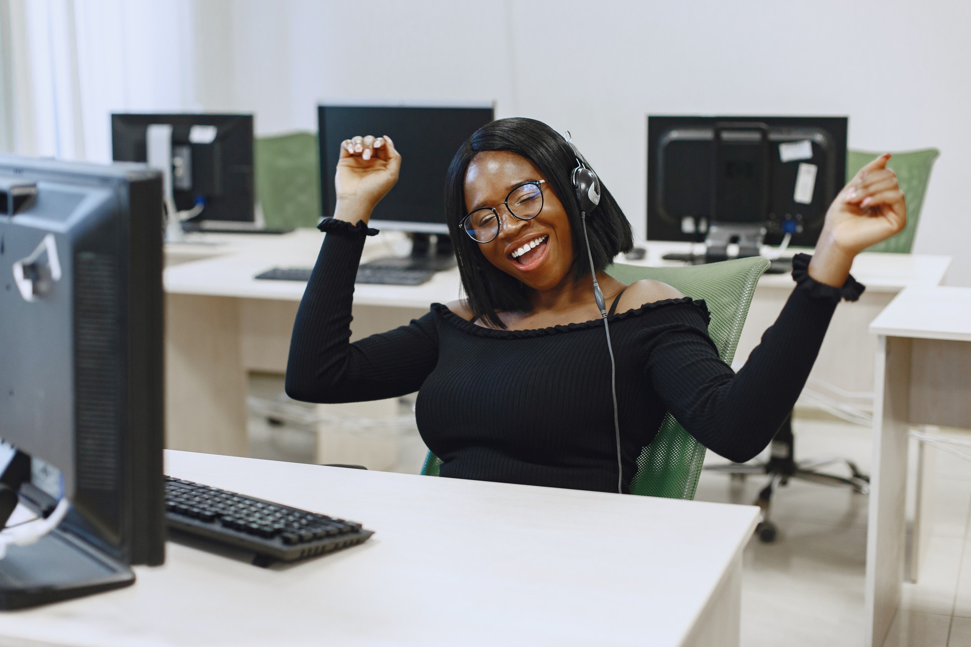 コンピュータサイエンスのクラスに座っているアフリカの女性。眼鏡をかけた女性。コンピューターの前に座っている女子学生。