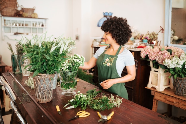 African young woman looking at flowers in vase