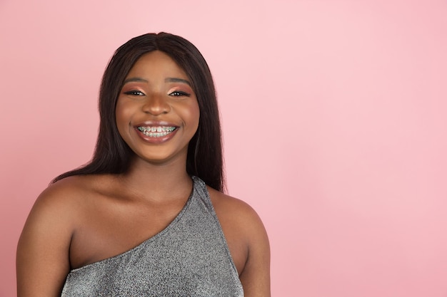 핑크 스튜디오 배경에 아프리카 젊은 여성의 초상화 인간의 감정 표정 청소년 판매 광고의 개념 개념