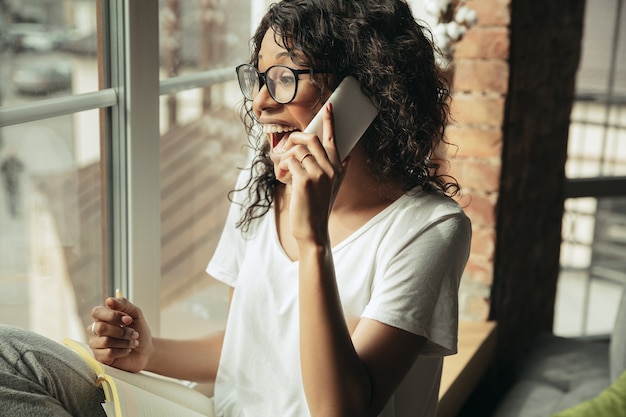 Foto gratuita donna afroamericana freelance durante il lavoro in ufficio durante la quarantena