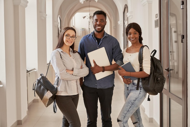 Africans and Caucasian standing on corridor of university