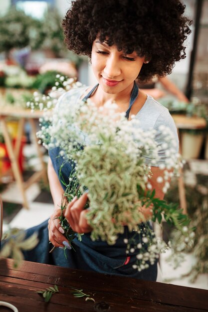 Afro african female florist holding bunch of white flowers