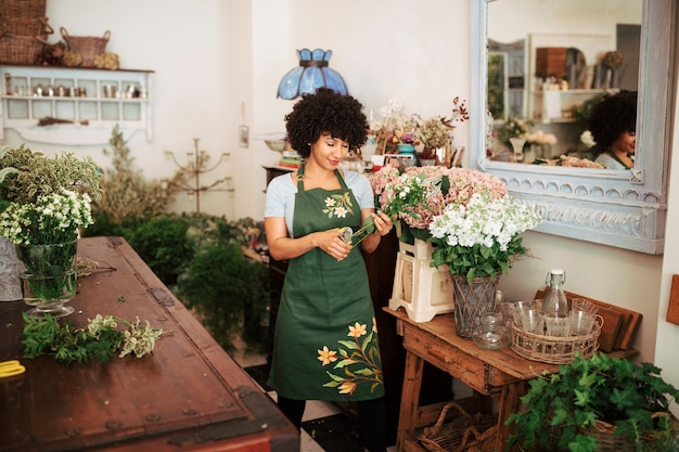 Afro african woman cutting stem of flowers