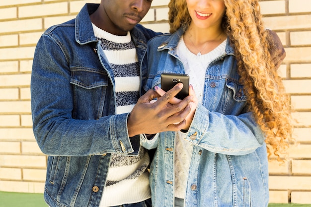 Free photo afro american couple looking at smartphone