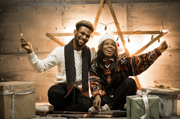 Afro american couple sitting with bengal lights