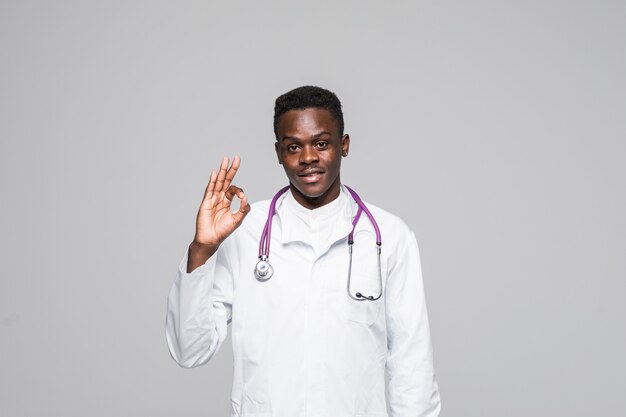 청진 기 괜찮아 제스처를 보여주는 아프리카 미국 의사는 회색 배경에 고립