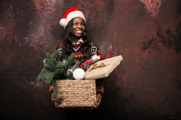 ボックスでクリスマスの装飾を保持しているアフロアメリカの女の子