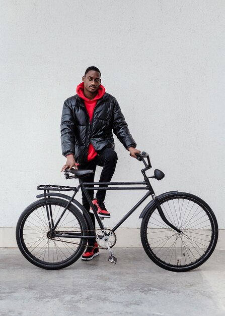 afro-american man holding his bicycle in front of him