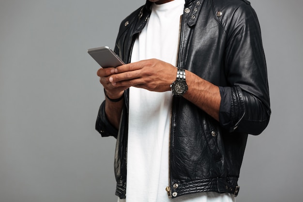 Free photo afro american man in leather jacket with smartphone