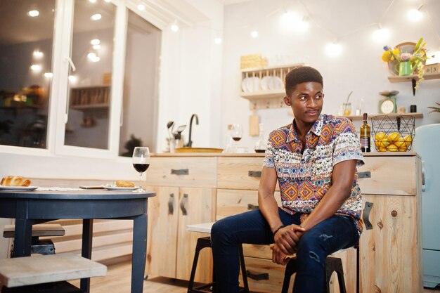 Afro american man sitting in kitchen at his romantic date