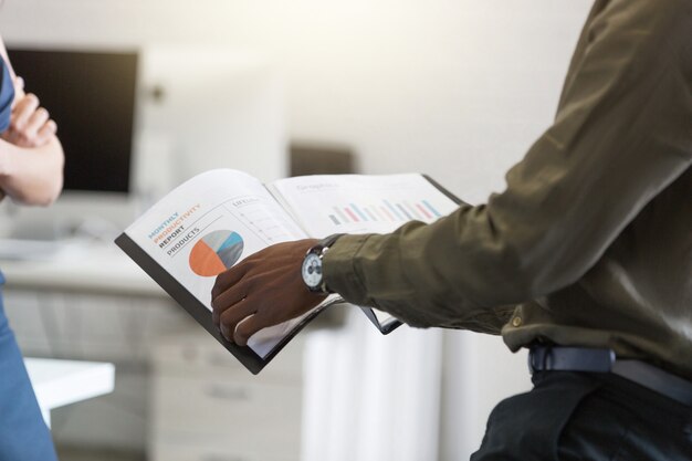 Afro american mans hands holding document in an office