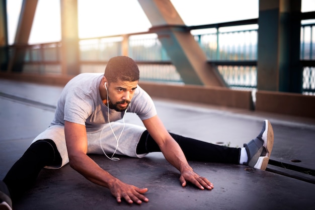 Afro American sportsman warming up his body for an outdoor training