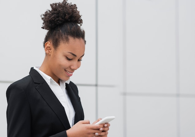 Foto gratuita donna afroamericana che controlla telefono