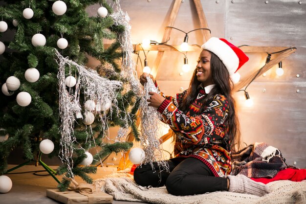 크리스마스 트리에 장난감을 매달려 아프리카 미국 여자