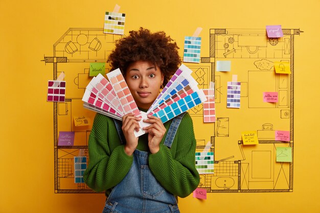 Afro American woman holds color samples for new apartment