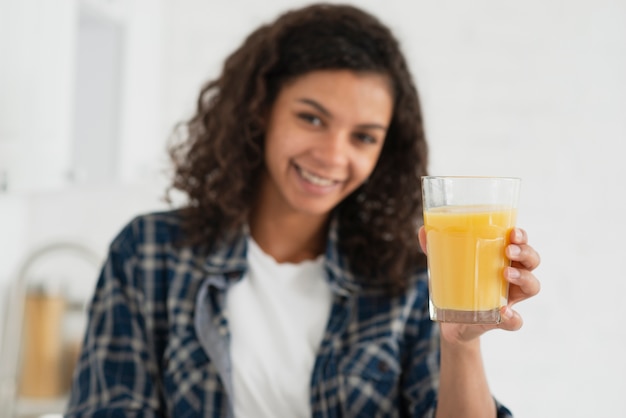 オレンジジュースを提供しているアフロアメリカンの女性