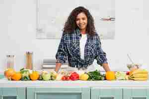 Free photo afro american woman posing next to vegetables