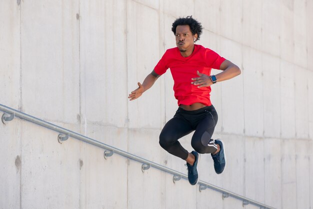 Afro athletic man doing exercise outdoors at stairs