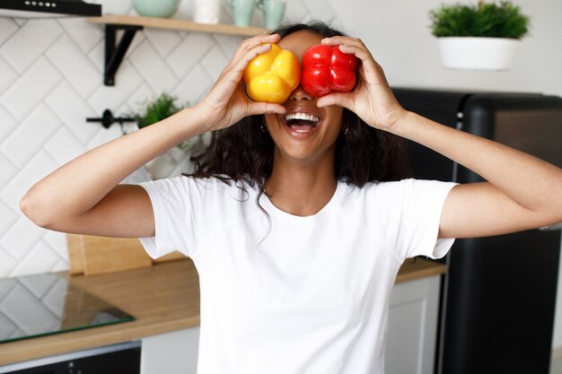 Free photo afro girl joying holds two peppers