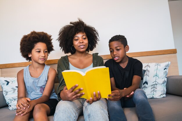 Afro mother reading a book to her children.