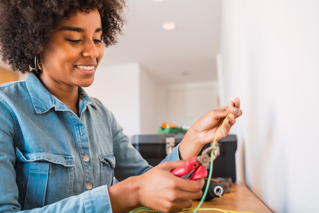 Afro woman fixing electricity problem at home.