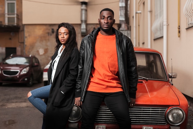 Afroamerican friends leaning on car