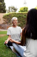 age difference female friends meeting up for yoga outdoors