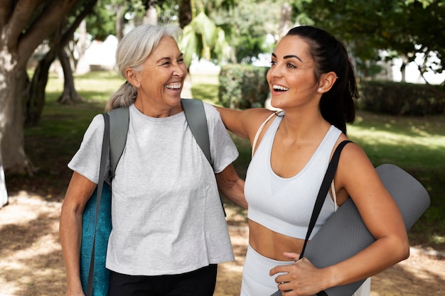 Amici di sesso femminile con differenza di età che si incontrano per lo yoga all'aperto