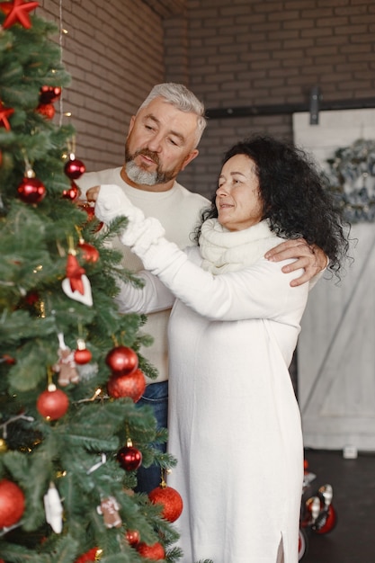 Concetto di età e persone. coppia senior a casa. donna in un maglione lavorato a maglia bianco.