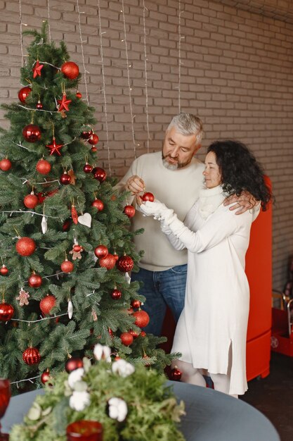 Age and people concept . Senior couple at home. Woman in a white knited sweater.