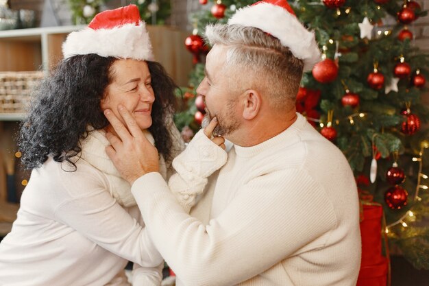 Age and people concept . Senior couple at home. Woman in a white knited sweater.